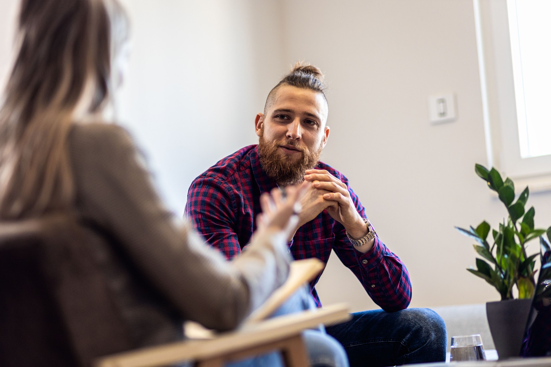 female hypnotherapist talking to young man during hypnosis session. female hypnotherapist talking to young man during hypnosis session.